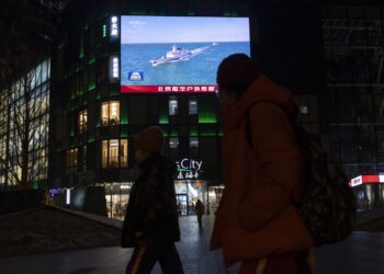 Los peatones pasan junto a una pantalla que transmite noticias sobre los ejercicios militares lanzados por China alrededor de Taiwán, en Beijing, China, el 29 de diciembre de 2025. Foto: EFE/EPA/ANDRES MARTINEZ CASARES