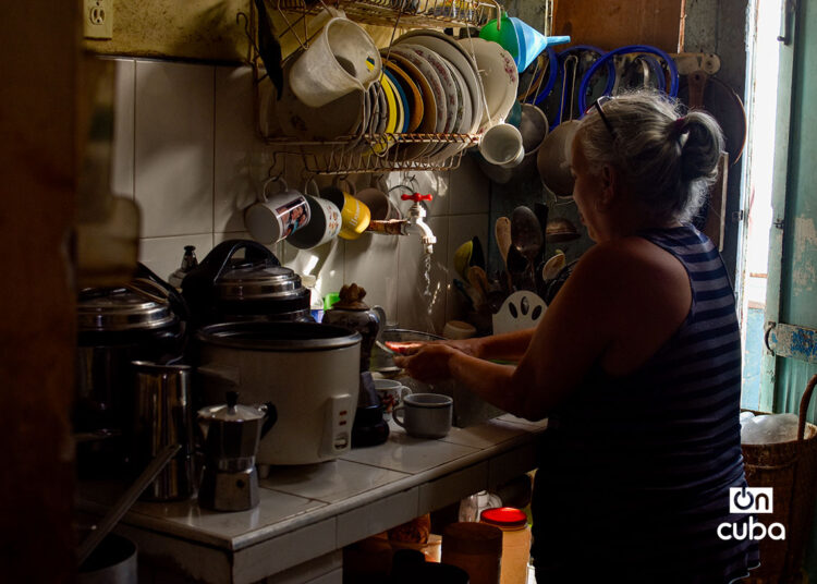 Una mujer hace labores en su cocina durante un apagón. Foto: Otmaro Rodríguez.