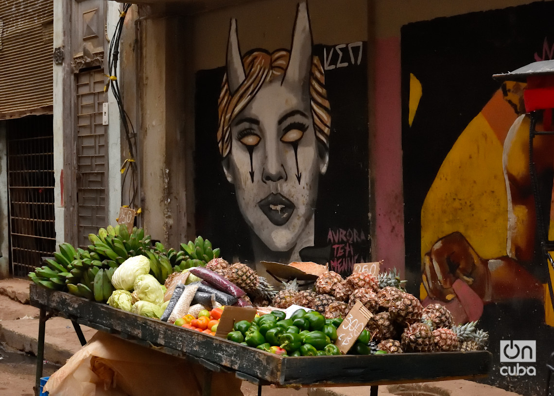 Una carretilla con productos agrícolas a la venta, junto a un mural callejero. Foto: Otmaro Rodríguez.