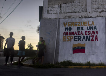 Niños y adolescentes junto a un mural con un mensaje en apoyo al Gobierno de Venezuela en Caracas Foto: Miguel Gutiérrez / EFE.