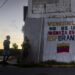 Niños y adolescentes junto a un mural con un mensaje en apoyo al Gobierno de Venezuela en Caracas Foto: Miguel Gutiérrez / EFE.