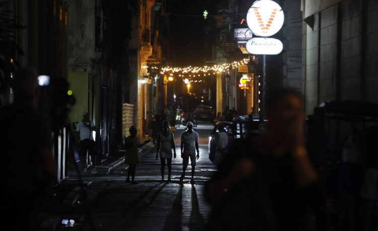 Personas caminan por una calle adornada con luces de Navidad en La Habana. Foto: Ernesto Mastrascusa / EFE.