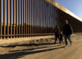 Fotografía de archivo del 28 de octubre de 2022 de una familia caminando junto al muro fronterizo en Yuma, Arizona, Estados Unidos. Foto: EFE/EPA/ Etienne Laurent / ARCHIVO.
