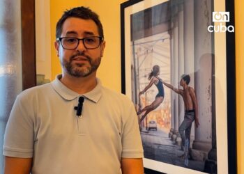 Gabriel Dávalos, fotógrafo y realizador audiovisual, junto a una de las fotos que forman parte de la exposición. Foto: Lied Lorain.