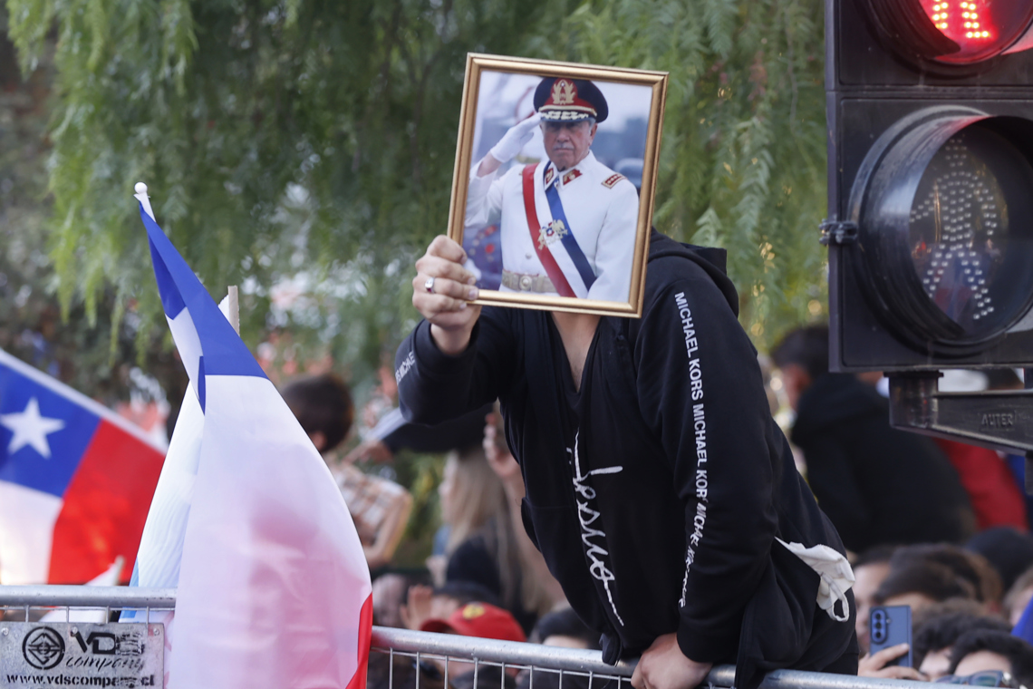 Un simpatizante del presidente electo de Chile, José Antonio Kast, sostiene una fotografía del dictador Augusto Pinochet, al conocer los primeros resultados de la segunda vuelta presidencial, en la que el ultraderechista obtuvo la victoria. Foto: Elvis González / EFE.