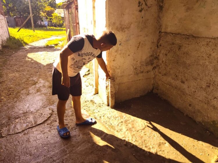 Hombre muestra este domingo hasta dónde llegó el nivel del agua. Foto: Henry Omar Pérez Yera/ ACN.
