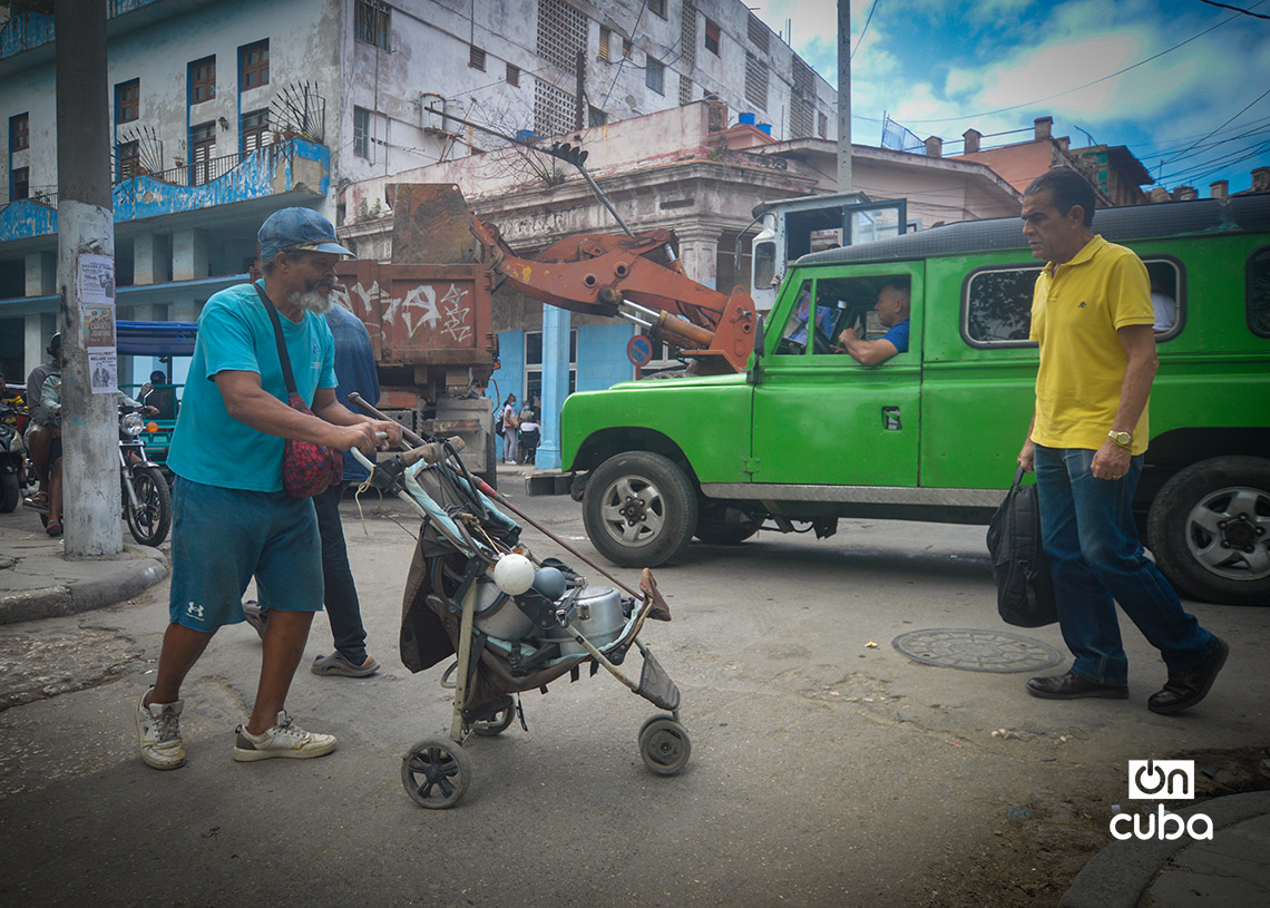 A man transports pots and other objects in an old children's car. Photo: Otmaro Rodríguez.