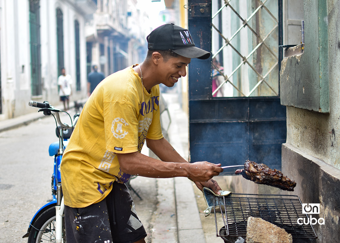 A young man grills meat on a street in Havana. Photo: Otmaro Rodríguez.