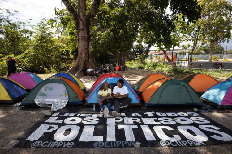Familiares de presos políticos esperan en carpas frente al centro penitenciario Rodeo I, por la posible excarcelación de sus allegados detenidos, en Zamora, estado de Miranda, en Venezuela. Foto: Ronald Peña R / EFE.