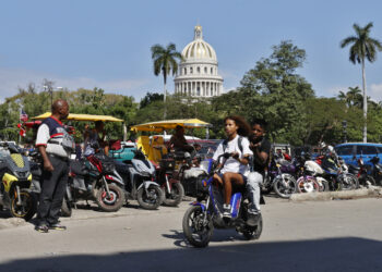 Personas pasean en moto cerca del Capitolio de La Habana este jueves, en La Habana. Foto: Ernesto Mastrascusa/EFE.