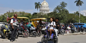 Personas pasean en moto cerca del Capitolio de La Habana este jueves, en La Habana. Foto: Ernesto Mastrascusa/EFE.