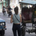 Fotografía de archivo del 11 de julio de 2024 que muestra a una mujer esperando un taxi en La Habana. Foto:  Yander Zamora/ EFE/ARCHIVO.