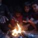 Familia de palestinos desplazados por la guerra se reúnen en torno al fuego para calentarse en este invierno en la ciudad Khan Younis, en Gaza. Foto: EFE/EPA/HAITHAM IMAD.