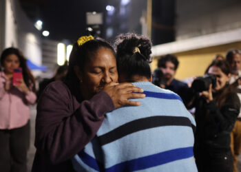 Personas se abrazan al conocer la aprobación de la ley de amnistía para presos políticos en Venezuela, frente al comando de la Policía Nacional Bolivariana (PNB) conocido como Zona 7, en Caracas, el 19 de febrero de 2026. Foto: Miguel Gutiérrez / EFE.