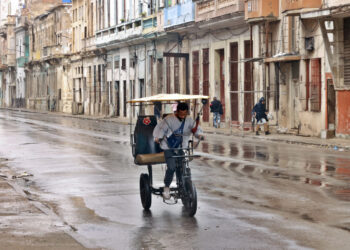 Un hombre conduce un bicitaxi por una calle de La Habana. Foto: Ernesto Mastrascusa / EFE.