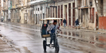 Un hombre conduce un bicitaxi por una calle de La Habana. Foto: Ernesto Mastrascusa / EFE.