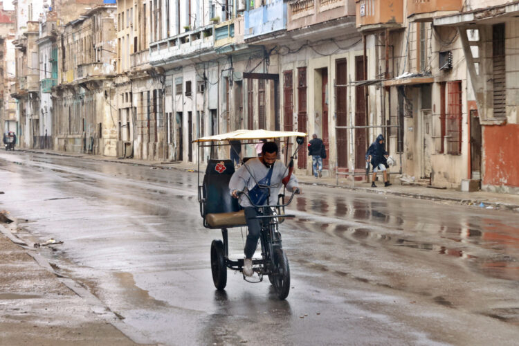 Un hombre conduce un bicitaxi por una calle de La Habana. Foto: Ernesto Mastrascusa / EFE.