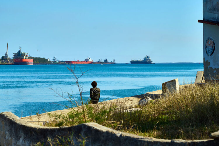 Una persona observa un barco de combustibles en la bahía de Matanzas. Foto: EFE/STR.