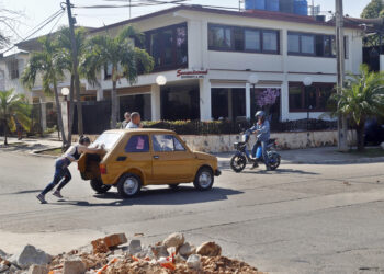 Una mujer empuja un vehículo, en La Habana, en medio de la grave crisis de combustible. Foto: Ernesto Mastrascusa/EFE.