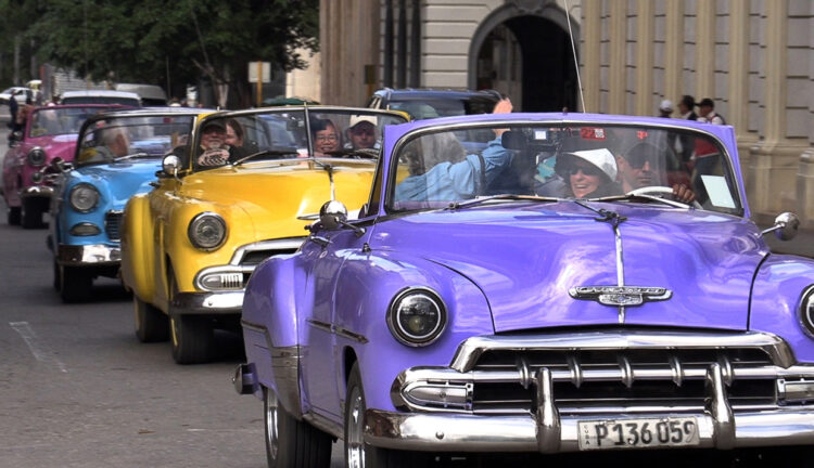 Turistas a bordo de automóviles clásicos recorren una calle de La Habana. Foto: Felipe Borrego/EFE
