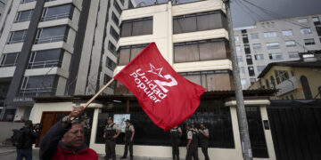 Un hombre agita una bandera durante una manifestación frente a la Embajada de Cuba en Ecuador este jueves. Foto: EFE/ José Jácome.