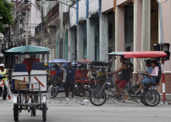 Bicitaxis transitan por una calle este martes, en La Habana. Foto:  Ernesto Mastrascusa/EFE.
