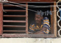 Un hombre observa desde una ventana, durante un apagón en La Habana. Foto: Ernesto Mastrascusa/EFE.