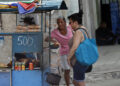 Personas compran alimentos en un puesto ambulante, en La Habana. Foto: Ernesto Mastrascusa/EFE.