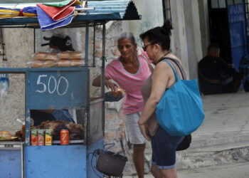 Personas compran alimentos en un puesto ambulante, en La Habana. Foto: Ernesto Mastrascusa/EFE.