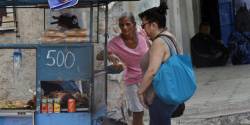 Personas compran alimentos en un puesto ambulante, en La Habana. Foto: Ernesto Mastrascusa/EFE.