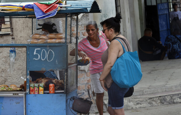 Personas compran alimentos en un puesto ambulante, en La Habana. Foto: Ernesto Mastrascusa/EFE.