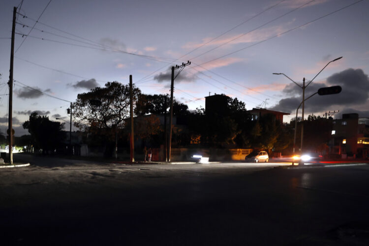 Vehículos transitan por una calle durante el apagón de este miércoles, en La Habana. Foto:  Ernesto Mastrascusa/EFE.