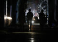 Personas caminan por una calle sin electricidad, en La Habana. Foto:  Ernesto Mastrascusa/EFE.
