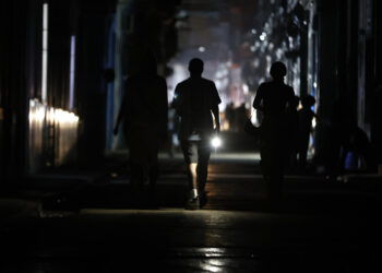 Personas caminan por una calle sin electricidad, en La Habana. Foto:  Ernesto Mastrascusa/EFE.