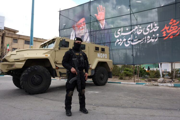 Un miembro de las fuerzas de seguridad iraníes junto a una pancarta de Ali Khameneí. Foto: ABEDIN TAHERKENAREH/EFE/EPA.