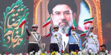 Miembros del ejército iraní ondean banderas nacionales mientras se colocan frente a un cartel del líder supremo de Irán, el ayatolá Mojtaba Jamenei, durante una manifestación en Teherán. Foto: Abedin Taherkenareh / EFE / EPA.