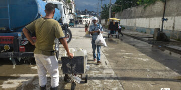 Un hombre espera para llenar pomos de agua, en un punto de llenado de pipas en La Habana. Foto: Otmaro Rodríguez.