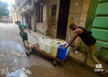 Dos hombres cargando agua en La Habana. Foto: Otmaro Rodríguez.