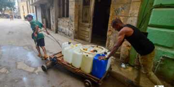 Dos hombres cargando agua en La Habana. Foto: Otmaro Rodríguez.