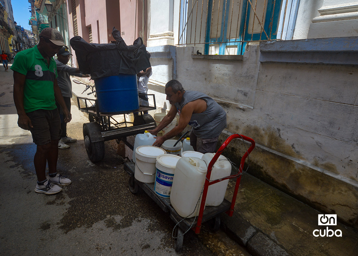 Personas llenan tanques y otros recipientes con agua, en La Habana. Foto: Otmaro Rodríguez.