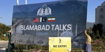 Trabajadores retiran una valla sobre las negociaciones entre Estados Unidos e Irán, tras la conclusión del diálogo sin un acuerdo, en Islamabad, Pakistán. Foto: Sohail Shahzad / EFE / EPA.