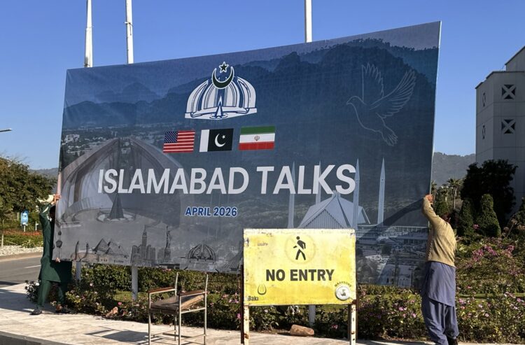 Trabajadores retiran una valla sobre las negociaciones entre Estados Unidos e Irán, tras la conclusión del diálogo sin un acuerdo, en Islamabad, Pakistán. Foto: Sohail Shahzad / EFE / EPA.