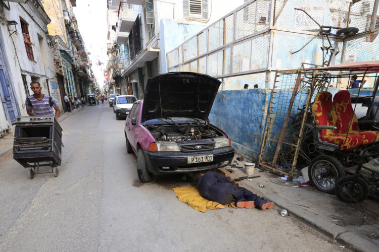 Una persona repara un automóvil en una calle este viernes en La Habana. Foto: Ernesto Mastrascusa/EFE.