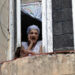Una mujer observa desde su ventana, en La Habana. Foto:  Ernesto Mastrascusa/EFE.