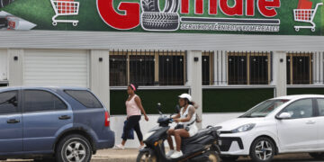 Personas pasan frente al local comercial Gomate en La Habana (Cuba). Foto: Ernesto Mastrascusa/EFE.