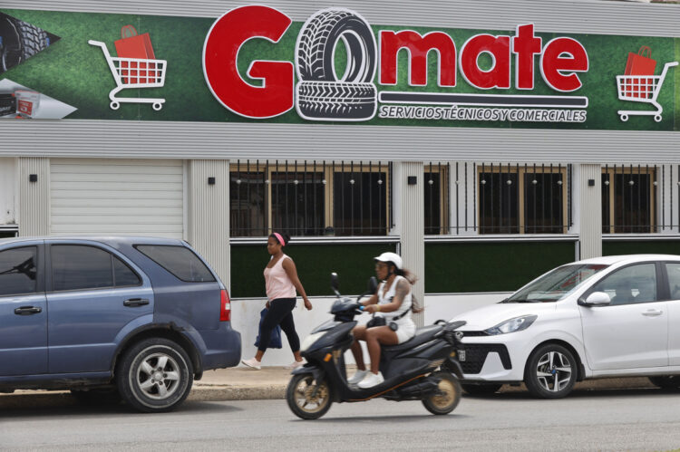 Personas pasan frente al local comercial Gomate en La Habana (Cuba). Foto: Ernesto Mastrascusa/EFE.