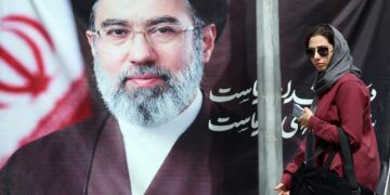 Una mujer iraní pasa junto a una fotografía del nuevo ayatolá, en una calle de Teherán,. Foto: ABEDIN TAHERKENAREH/EFE/EPA.