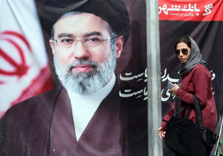 Una mujer iraní pasa junto a una fotografía del nuevo ayatolá, en una calle de Teherán,. Foto: ABEDIN TAHERKENAREH/EFE/EPA.