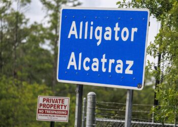 El letrero de Alligator Alcatraz permanece colocado fuera de las puertas del centro de detención Alligator Alcatraz en Ochopee, Florida, EE. UU., el 10 de mayo de 2026, mientras activistas protestan afuera exigiendo que se cierre la instalación. Foto: EFE/EPA/CRISTOBAL HERRERA-ULASHKEVICH.