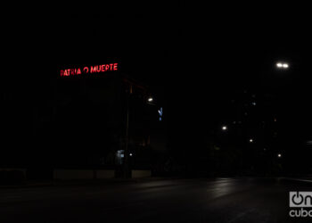 Un cartel lumínico con la frase "Patria o Muerte" se observa en una calle a oscuras en La Habana. Foto: Kaloian.